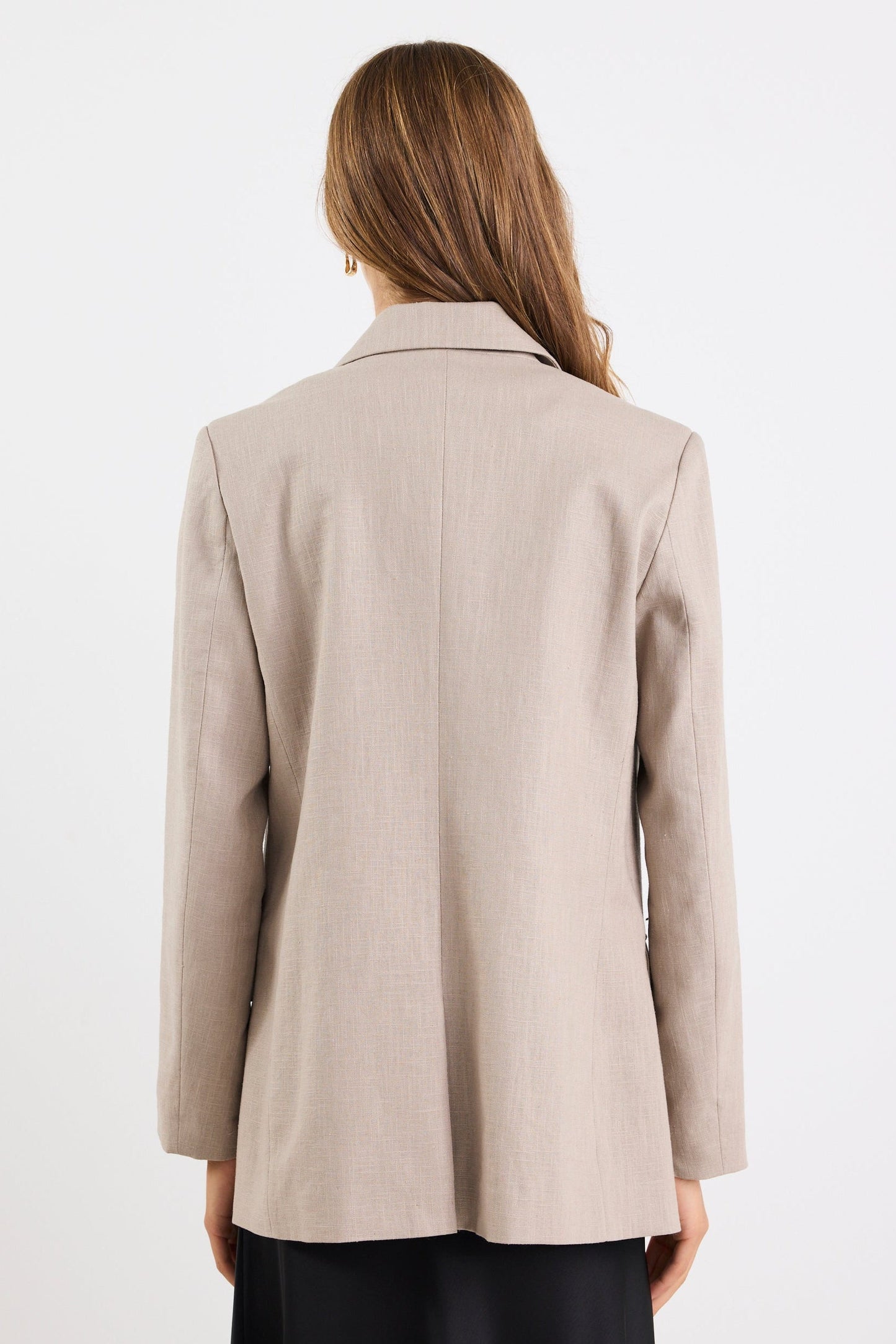 Woman wearing a beige blazer against a white background
@col_pattern