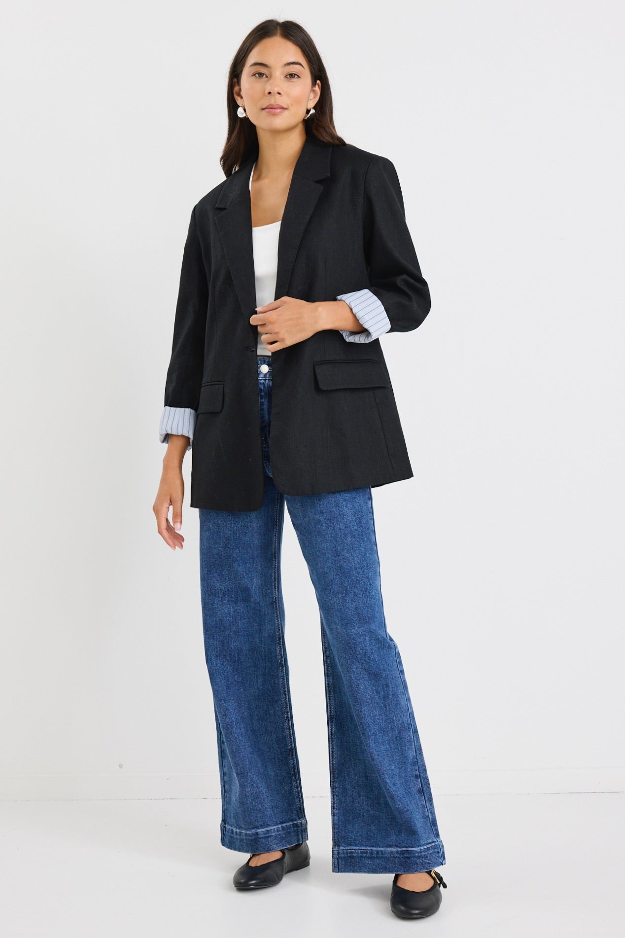 model wears a black linen blazer with blue stripe lining