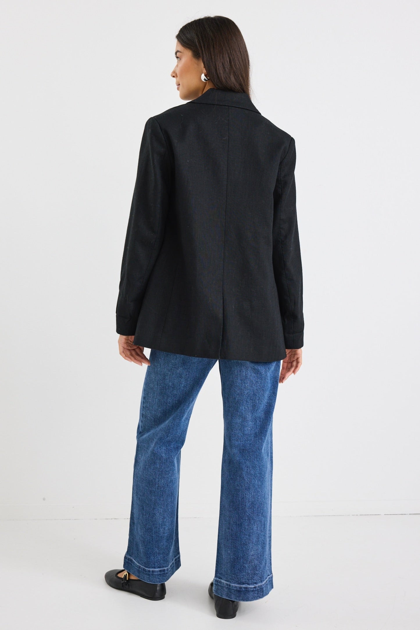 model wears a black linen blazer with blue stripe lining