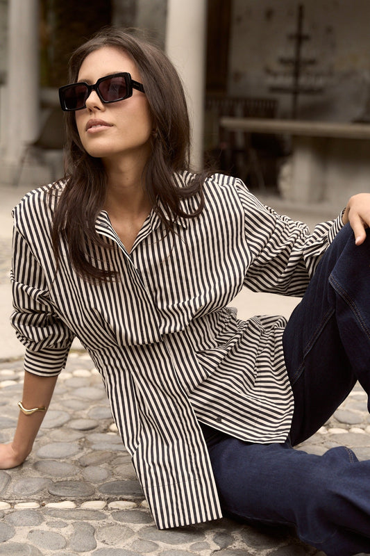 Model wears a black and white stripe collared shirt